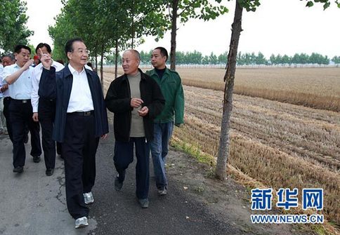 這是6月9日，溫家寶在長葛市石象鄉(xiāng)坡李王村的田間小路上與坡李王村支部書記李福成邊走邊聊。新華社記者龐興雷攝