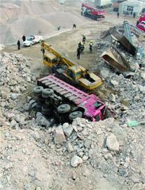 自卸車滾落20米司機困車內